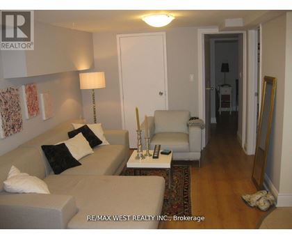A living room with a couch, chair, and lamp.