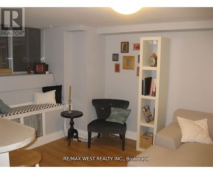 A living room with a black chair and a white bookshelf.