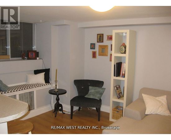 A living room with a black chair and a white bookshelf.