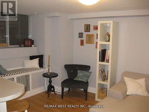 A living room with a black chair and a white bookshelf.