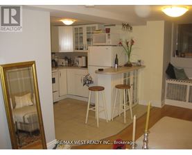 A kitchen with white cabinets and a fridge.