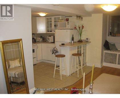 A kitchen with white cabinets and a fridge.