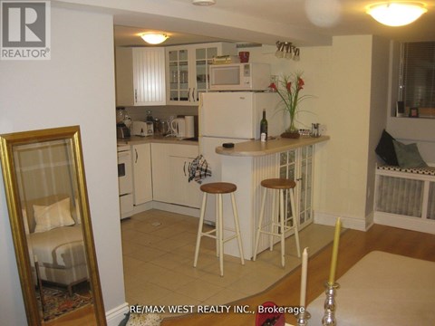 A kitchen with white cabinets and a fridge.