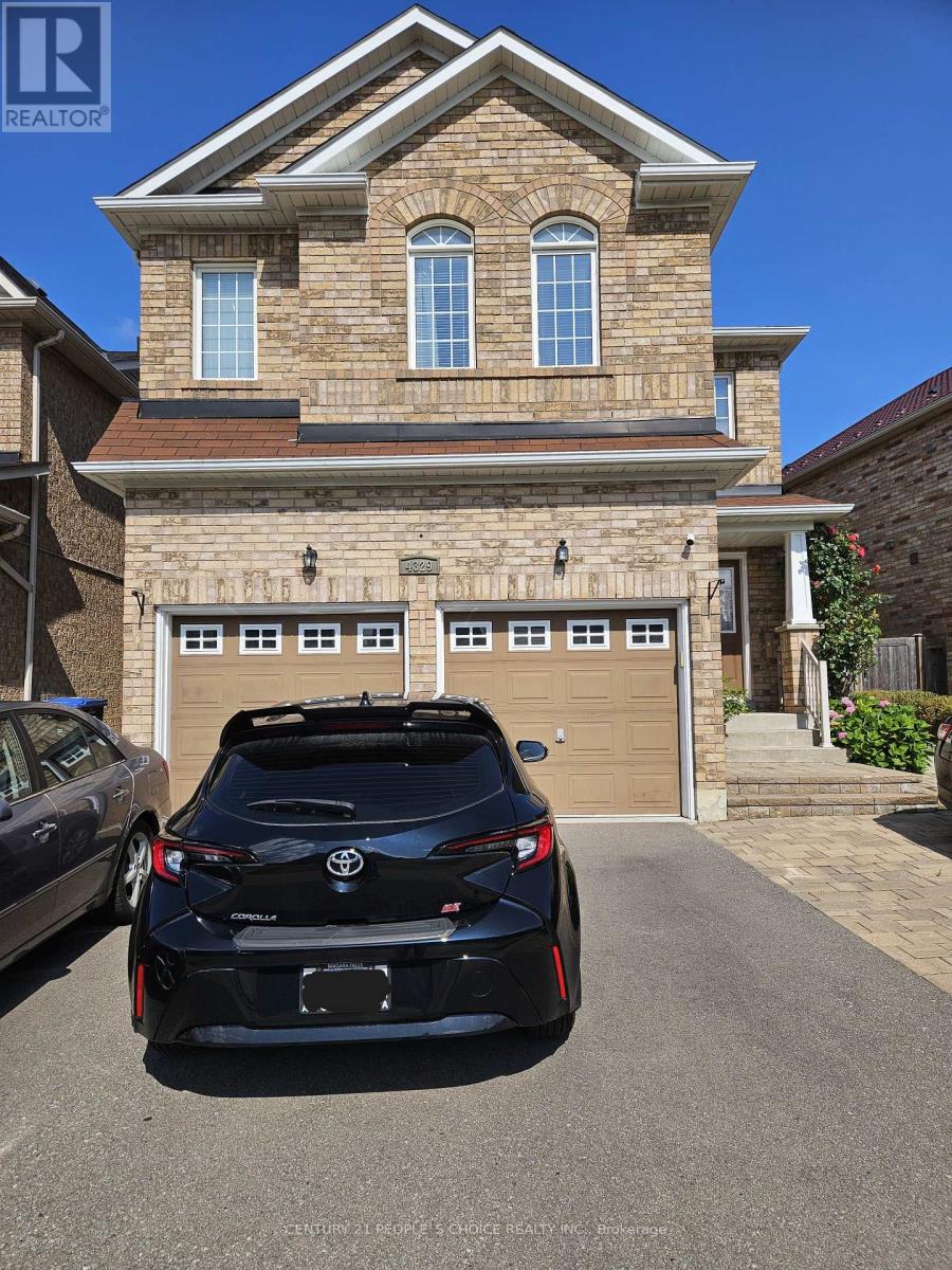 A black sports car is parked in front of a two-story house.