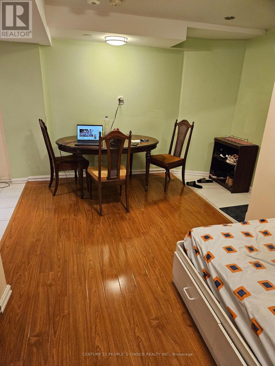 A room with a table and chairs and a laptop on it.