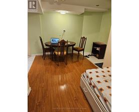 A room with a table and chairs and a laptop on it.