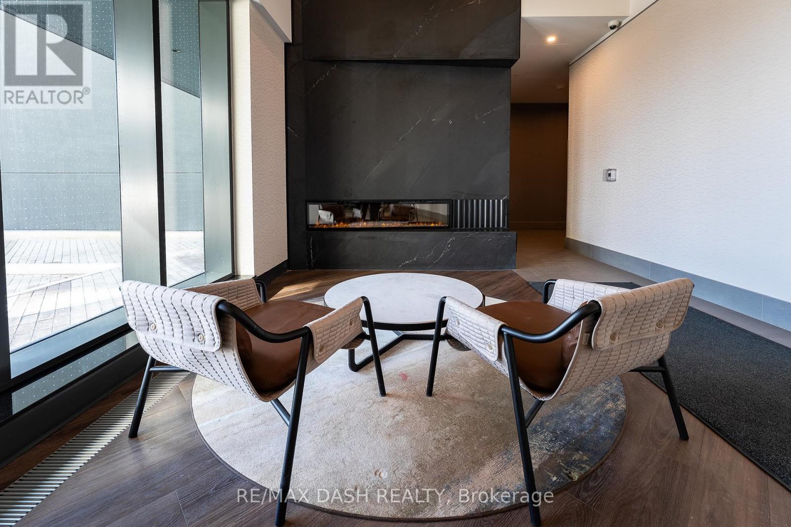 A modern living room with a fireplace and a glass wall.