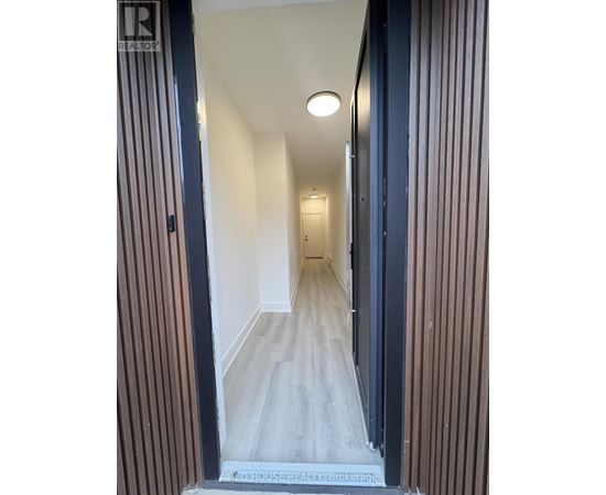 A hallway with a wooden floor and striped walls.