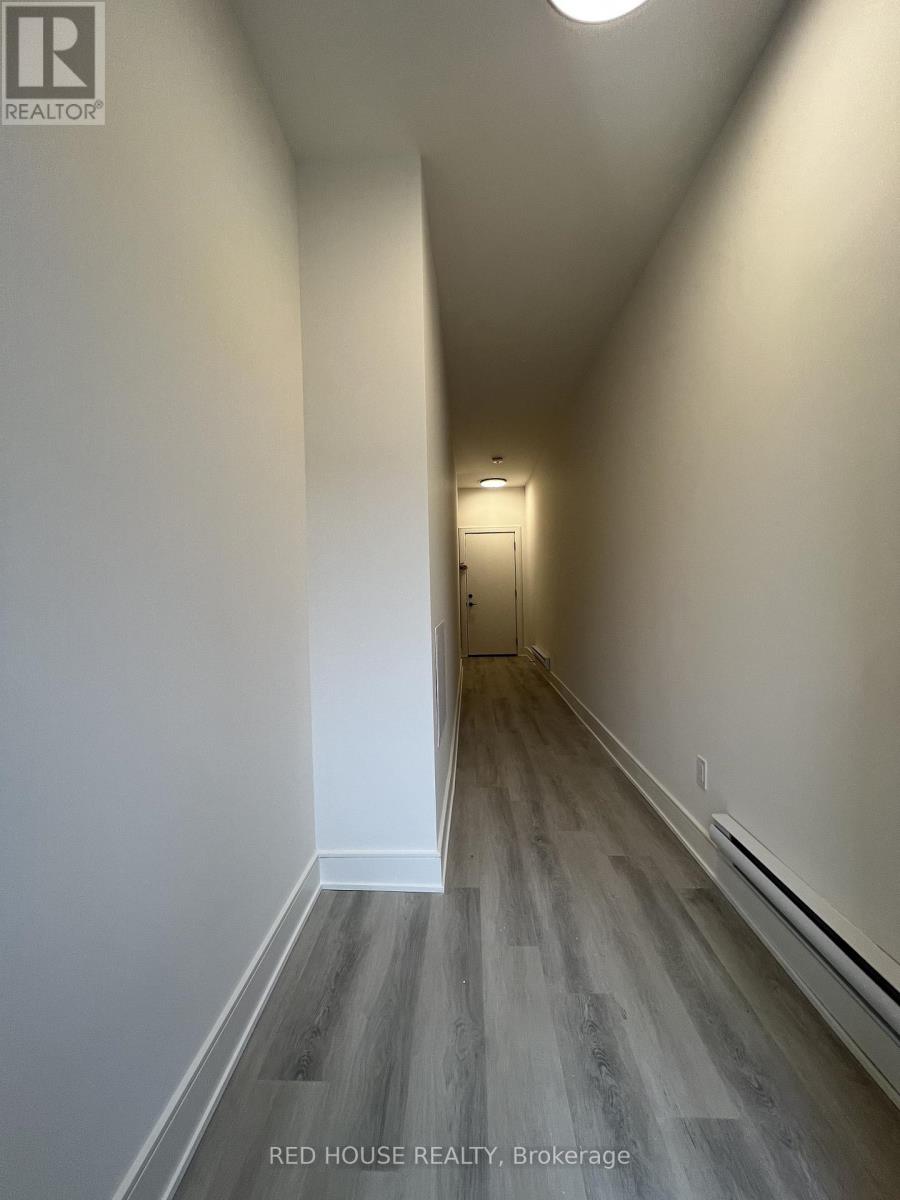 A hallway with wood flooring and white walls.