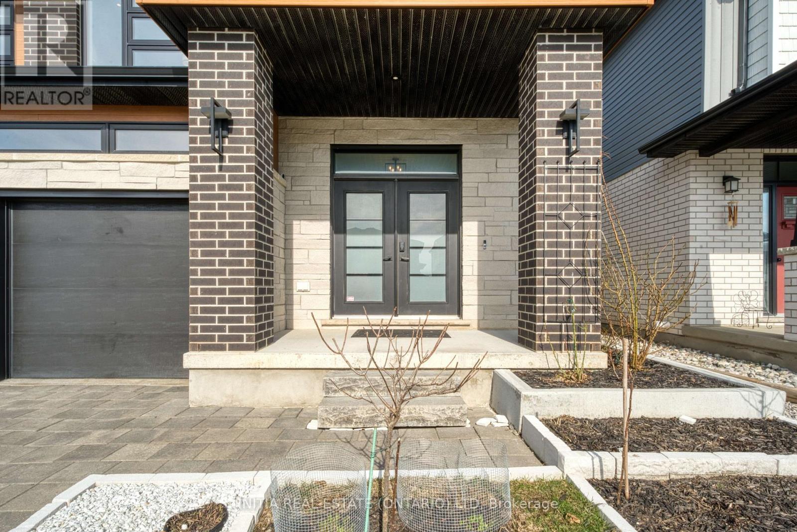 A modern house entrance with a glass door and a brick pillar.