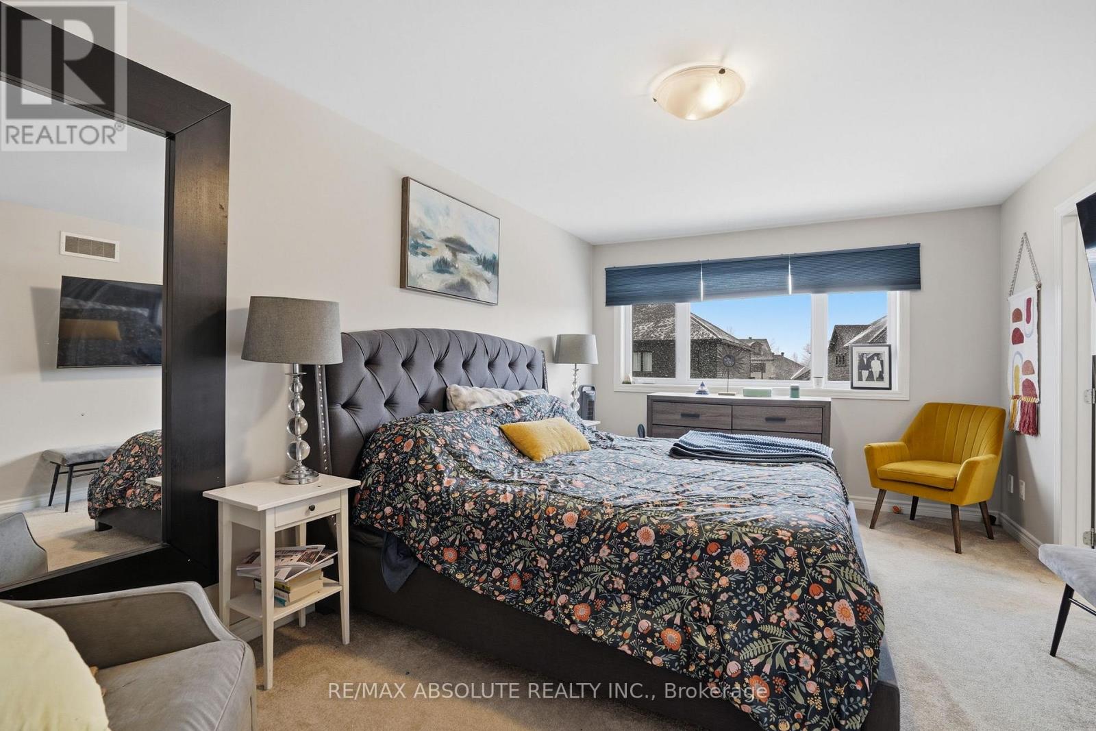 A bedroom with a large bed and a yellow chair.