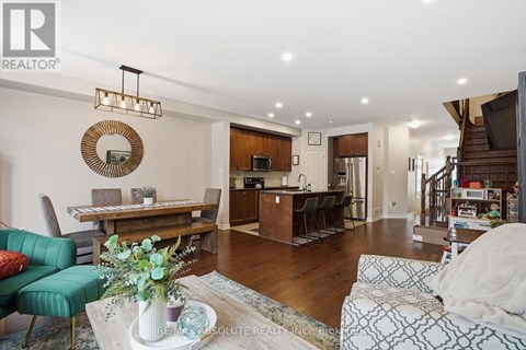 A living room with a green couch and a coffee table with a vase of flowers on it.