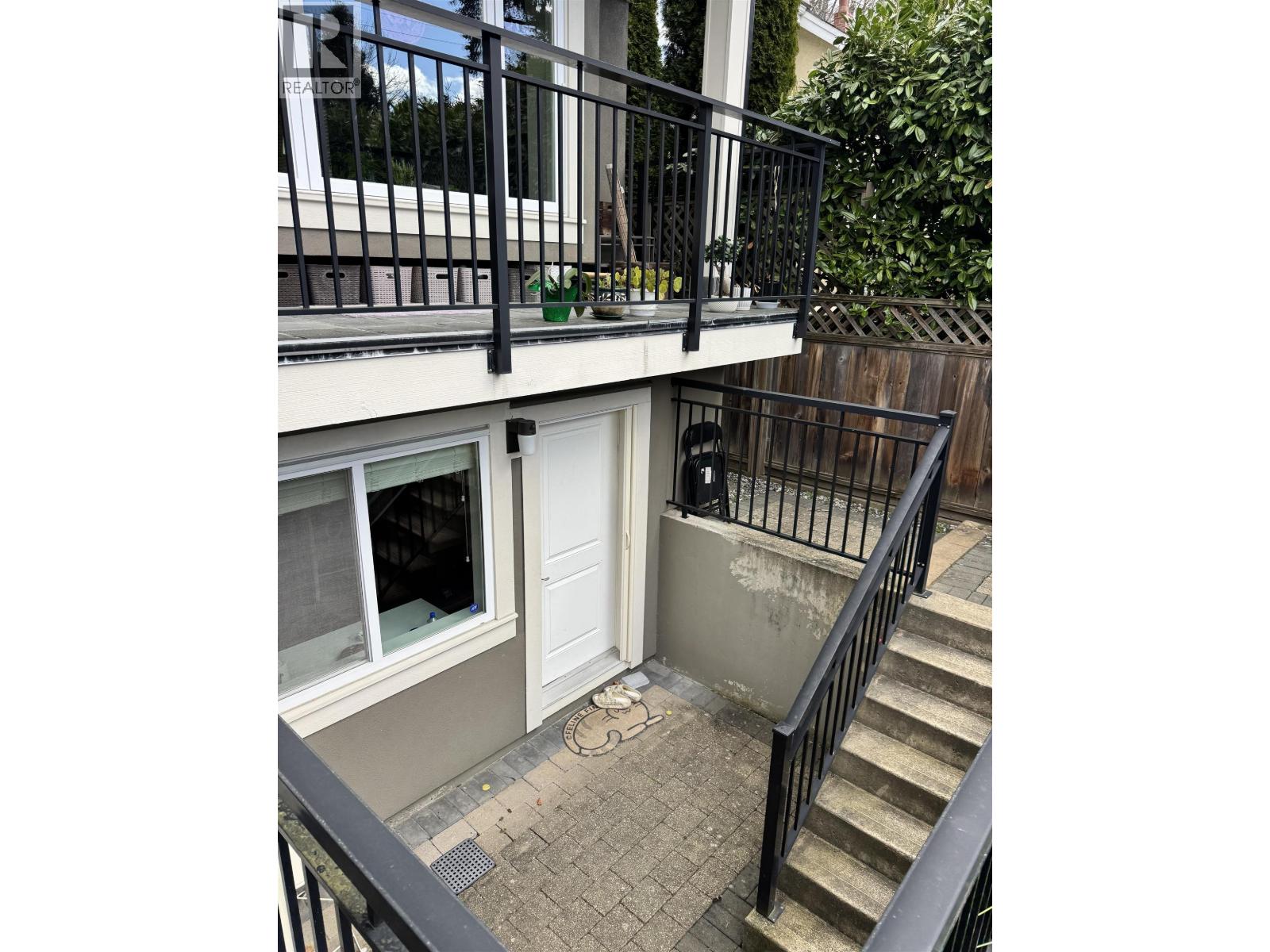 A balcony with a black railing and a white door.