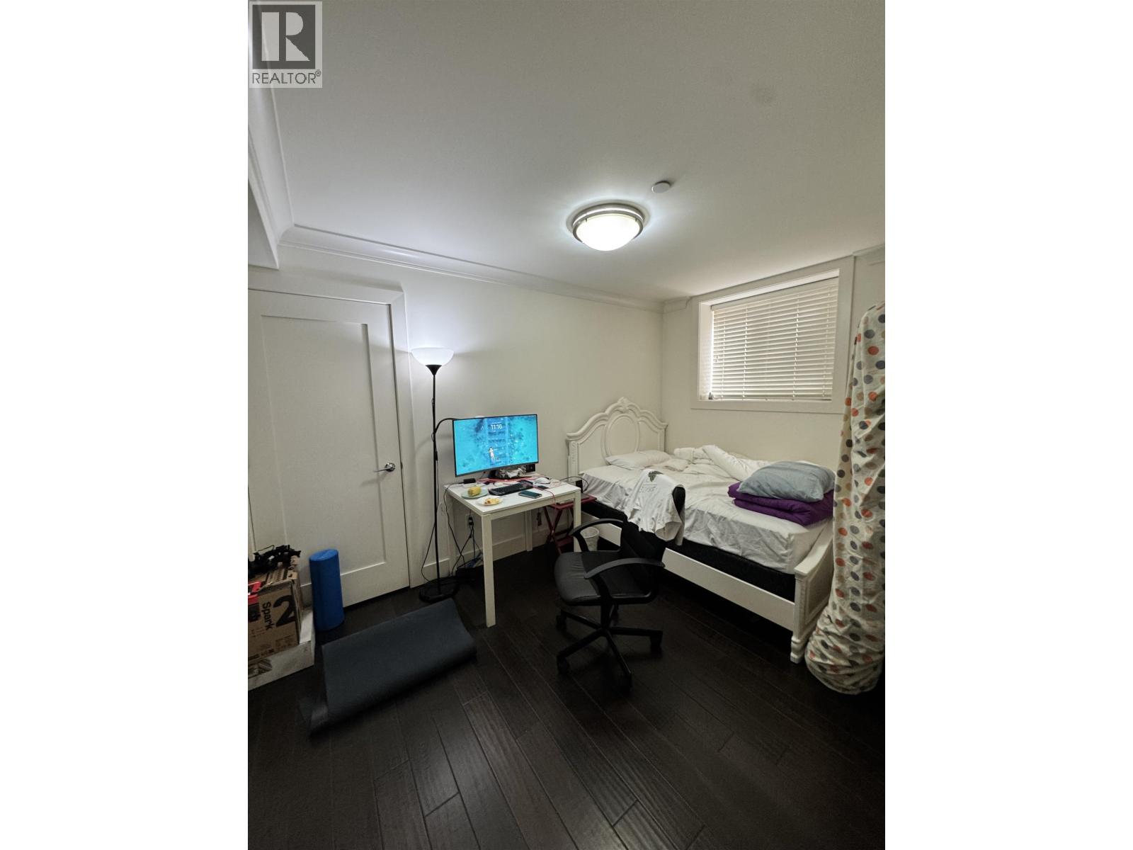 A bedroom with a bed, desk, and chair.