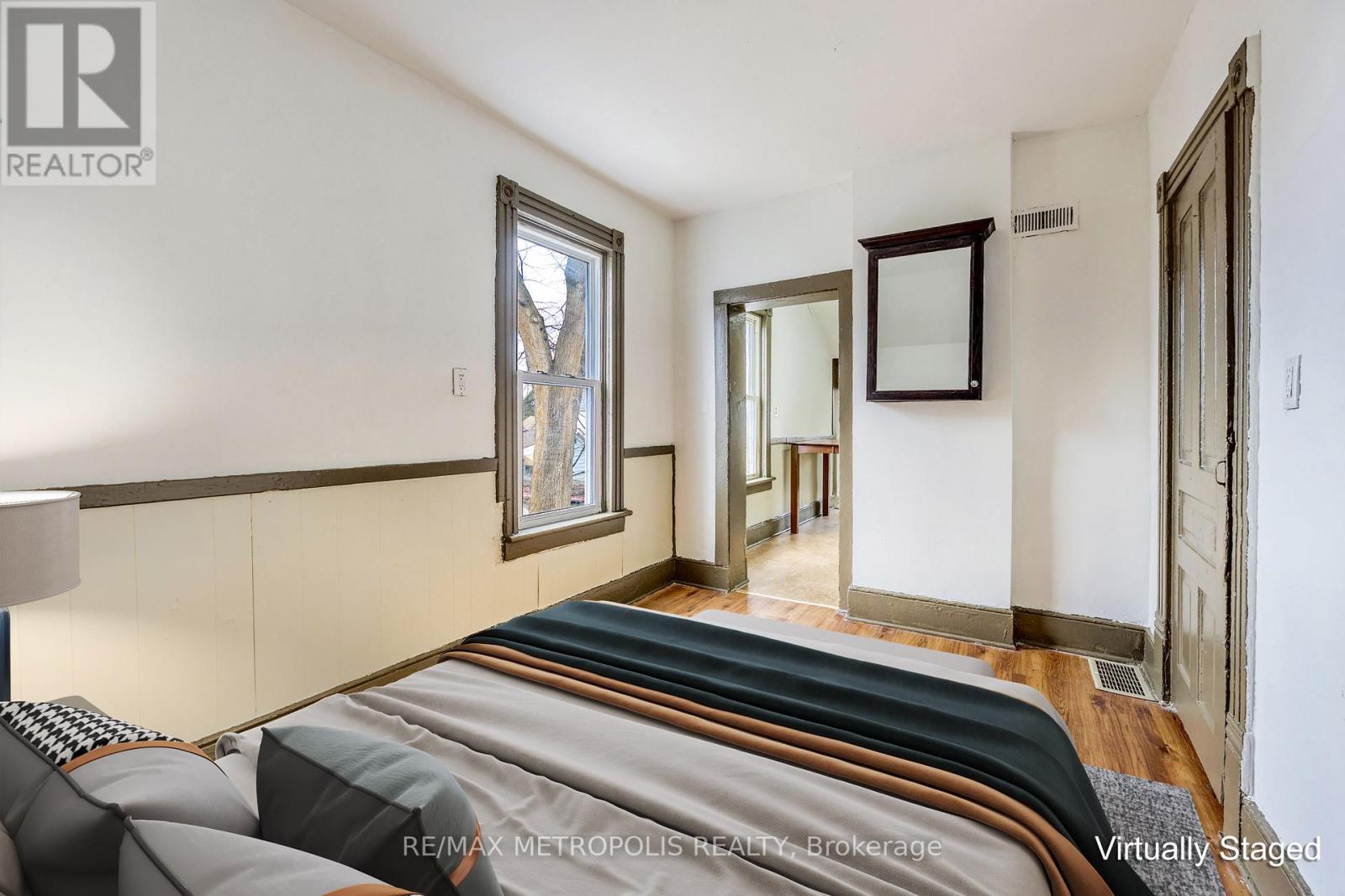 A bedroom with a bed in the foreground and a mirror on the wall.