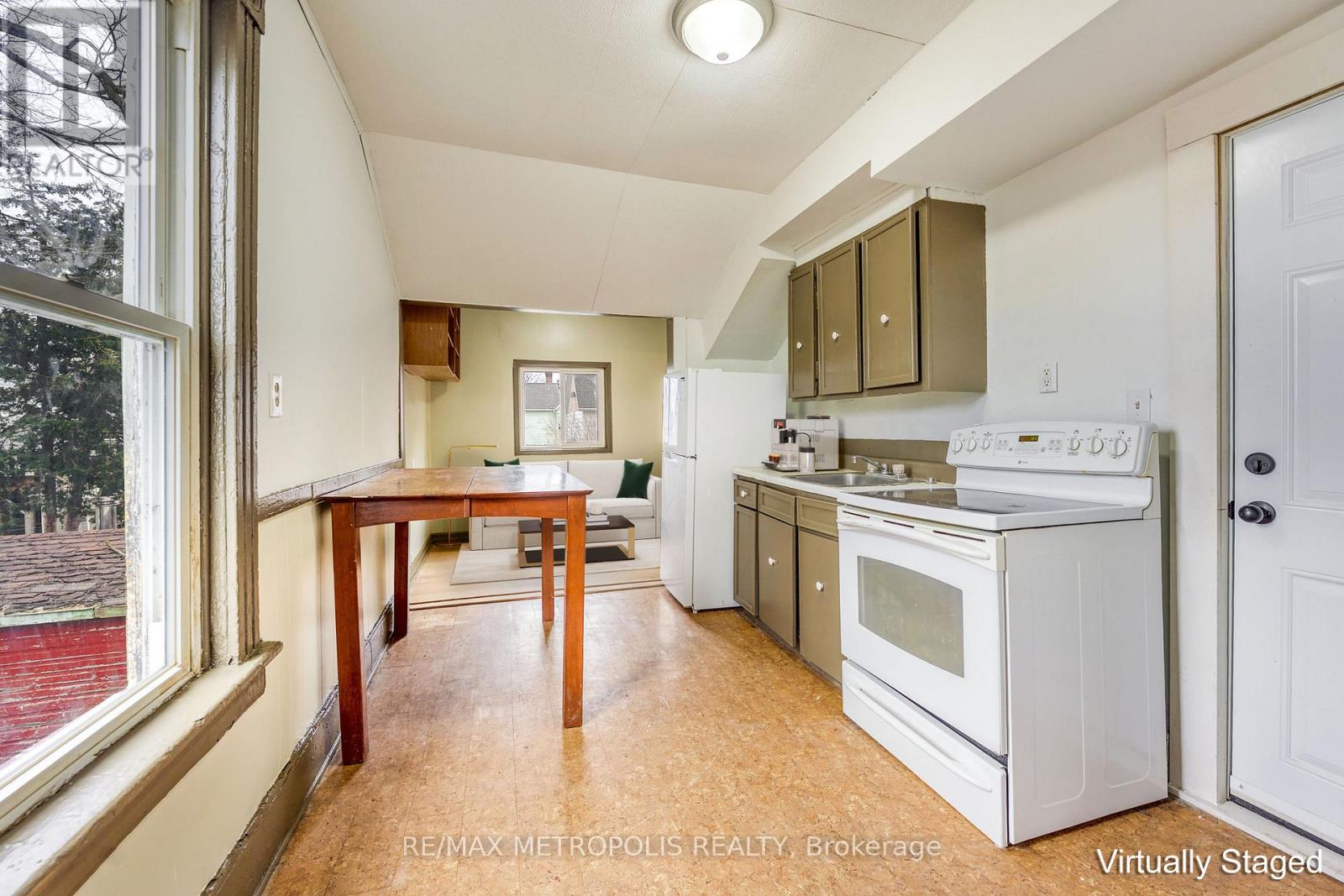 A kitchen with white appliances and wooden floors.