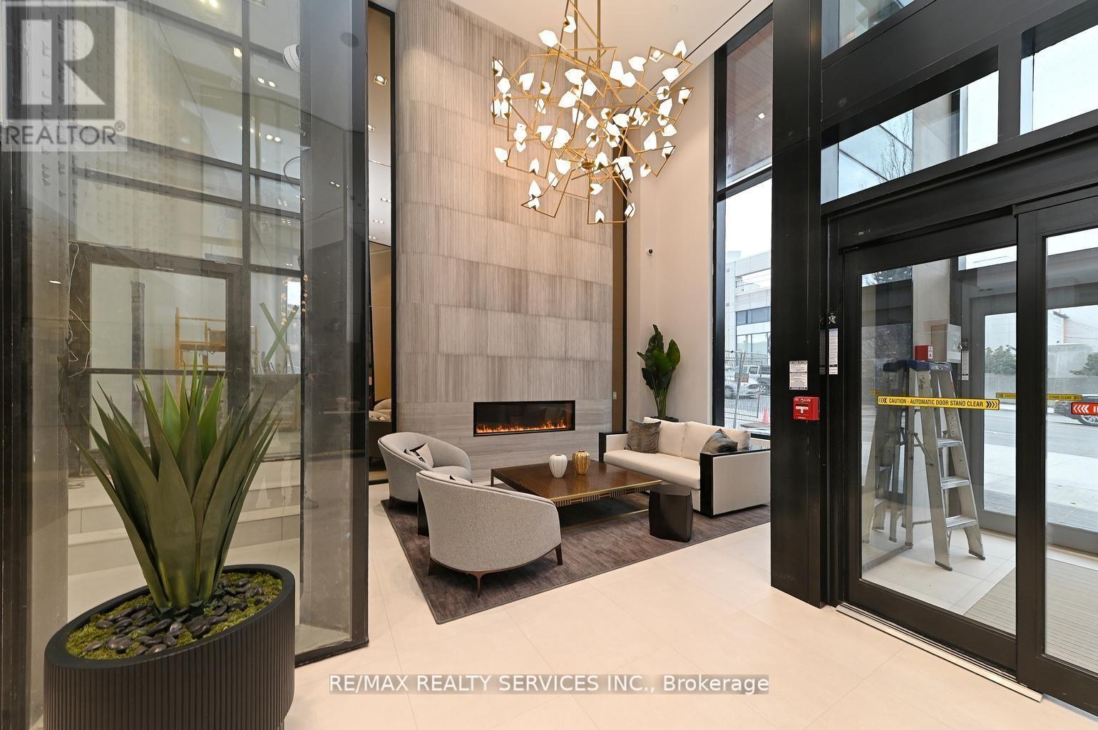 A modern living room with a fireplace and a chandelier.