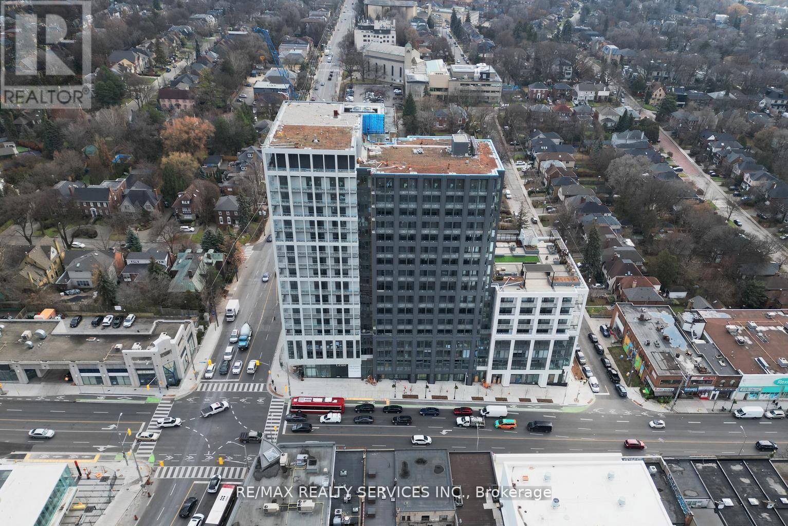 A large building with a blue roof is in the middle of a city street.