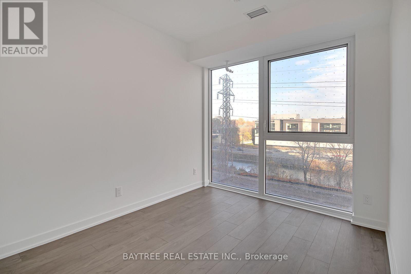 A room with a view of a power line and buildings outside the window.