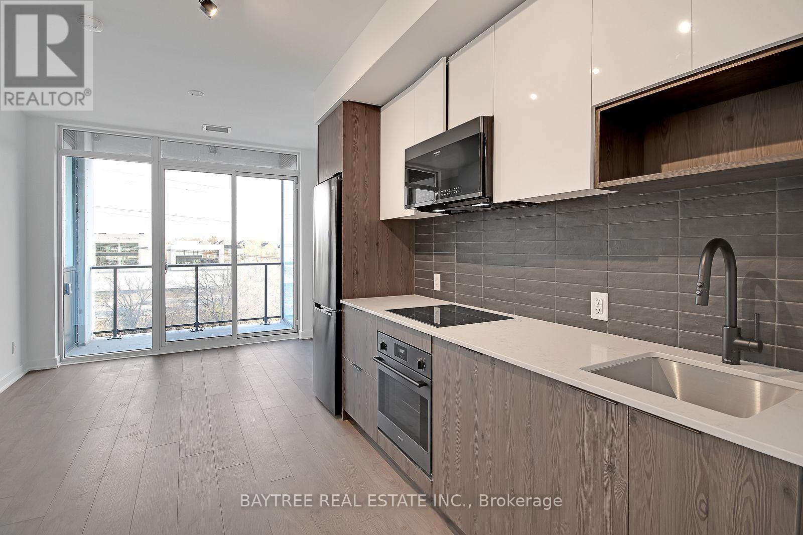 A modern kitchen with wooden cabinets and a stainless steel sink.