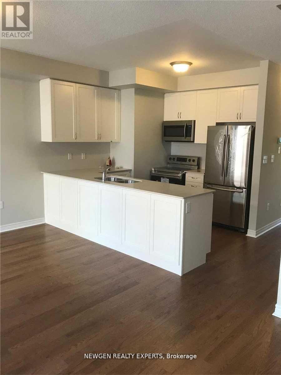 A kitchen with white cabinets and a wooden floor.
