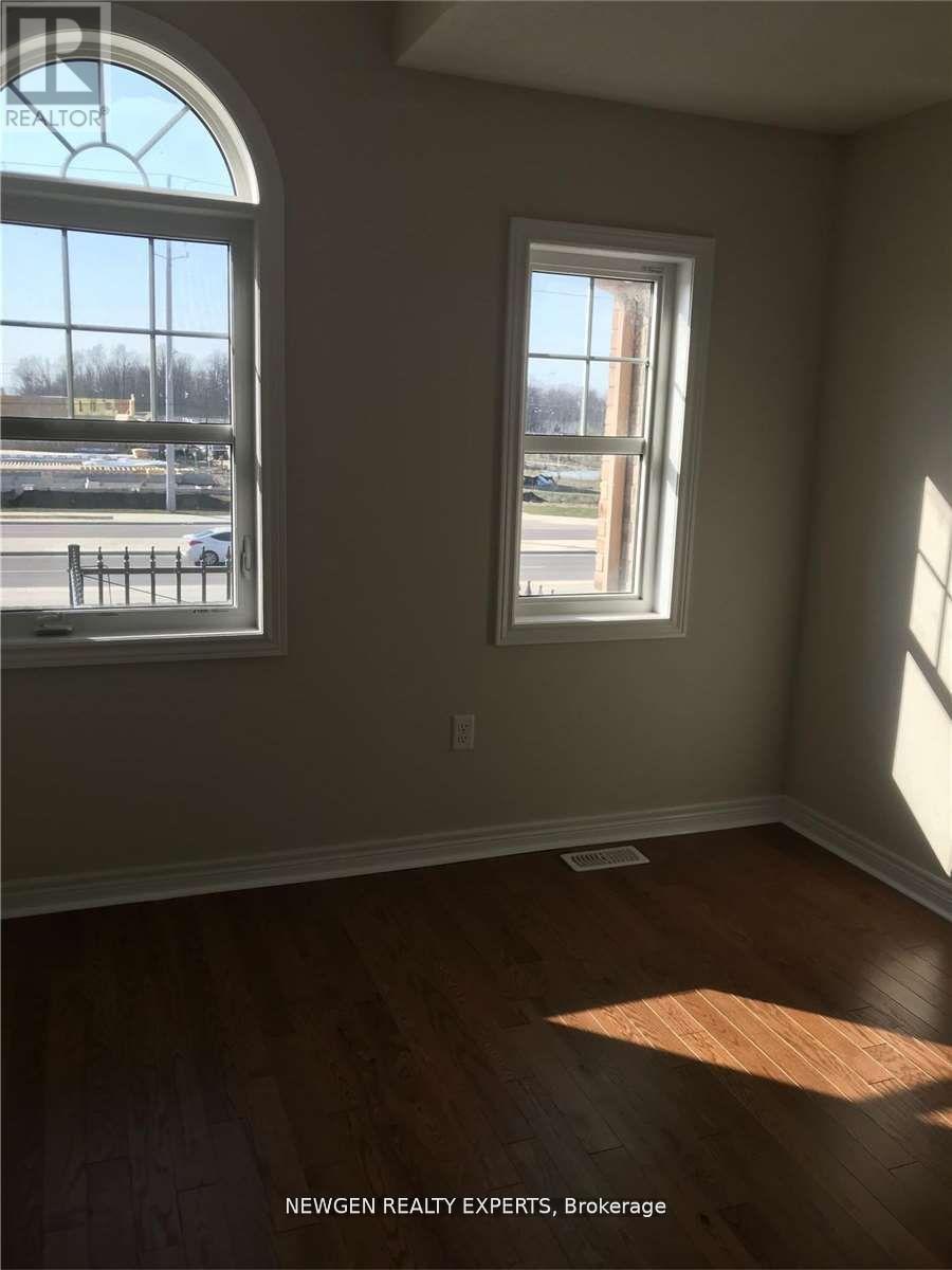 A room with a large window and a smaller window with a view of a parking lot.