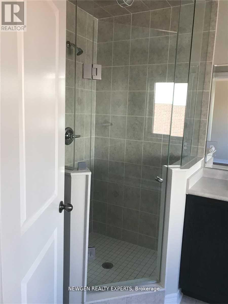 A shower area with a glass door and a white door.