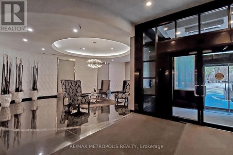 A modern living room with a glass table and a chandelier.