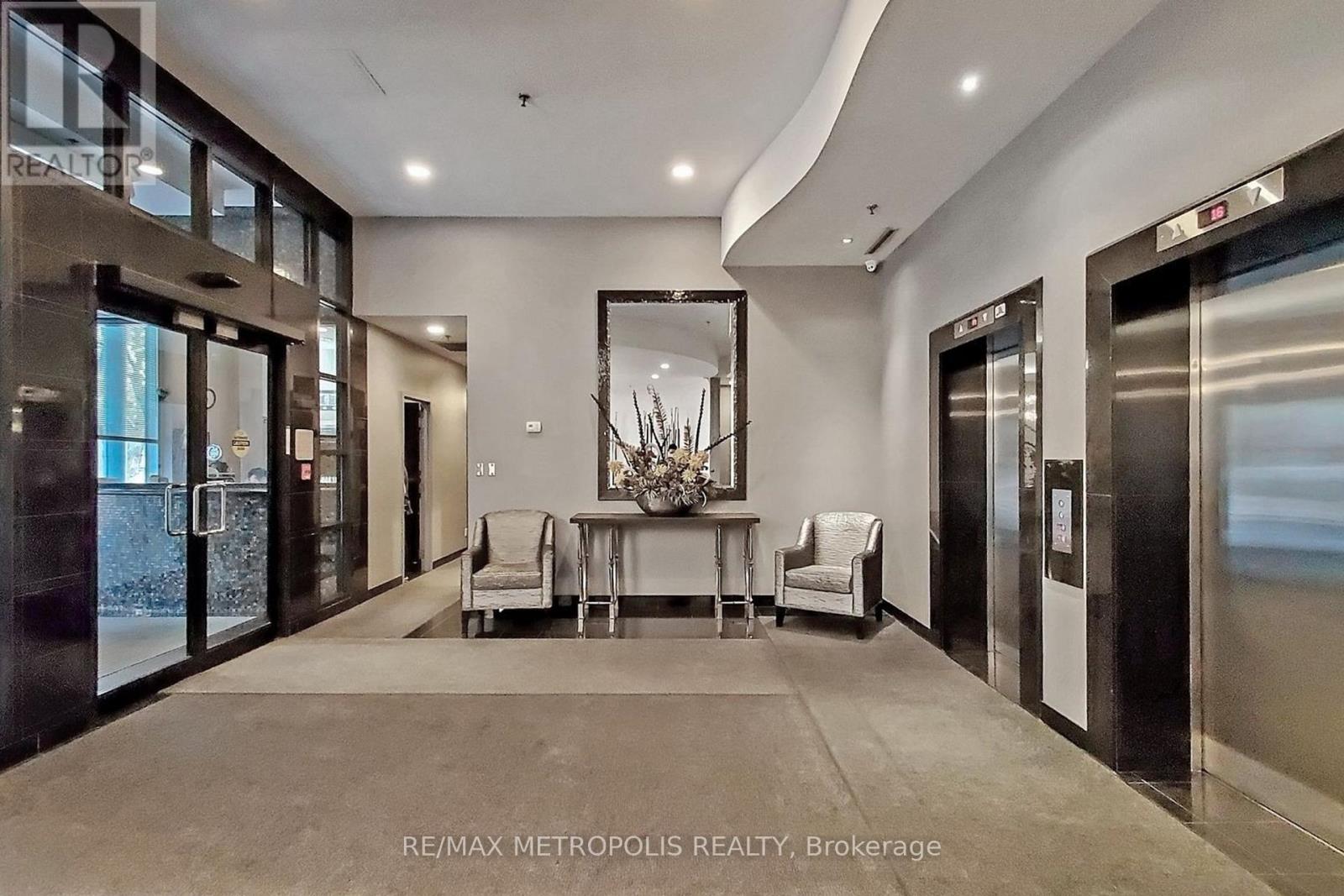 A spacious lobby with a dining table set up with chairs and a large mirror on the wall.