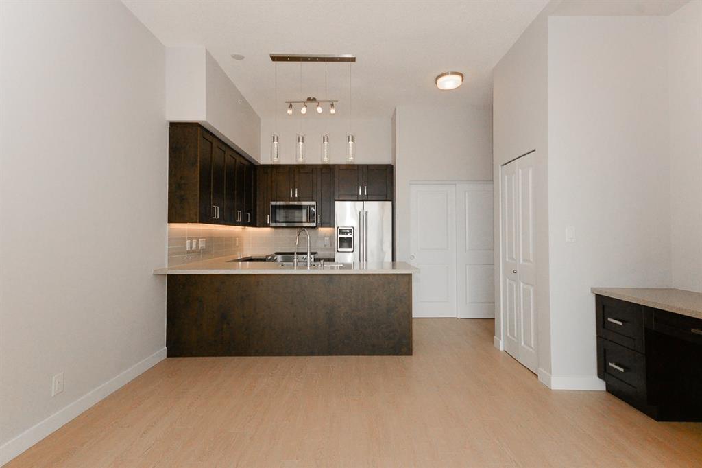 A kitchen with a white wall and a brown counter.