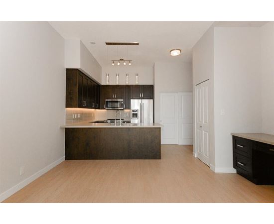 A kitchen with a white wall and a brown counter.