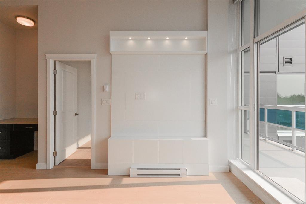 A white interior space with a large window and a white door.