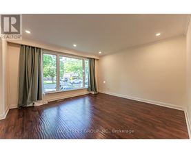 A room with a window and a wooden floor.