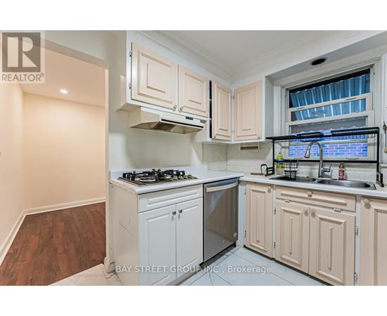 A kitchen with white cabinets and a stove top oven.