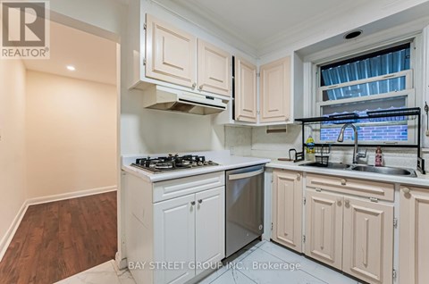 A kitchen with white cabinets and a stove top oven.