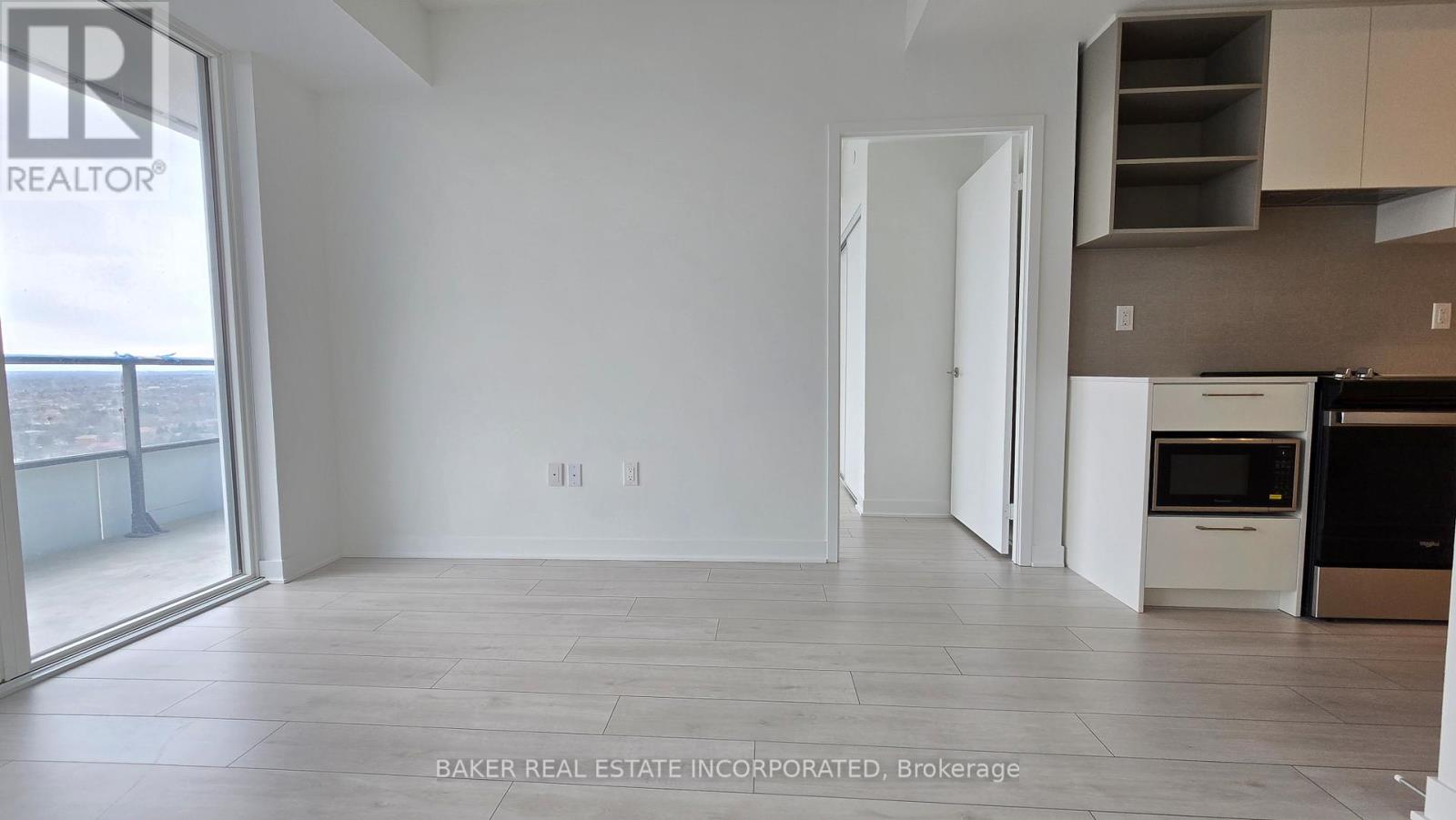 A spacious, empty room with a view of the outside balcony.