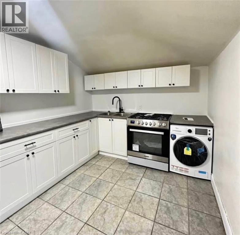A kitchen with white cabinets and a black stove top oven.