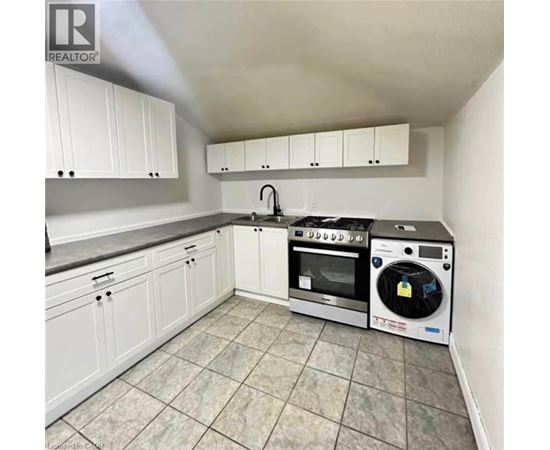 A kitchen with white cabinets and a black stove top oven.