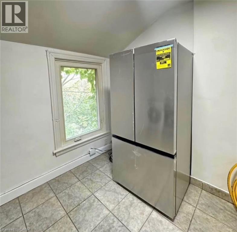 A small kitchen with a refrigerator and a window.