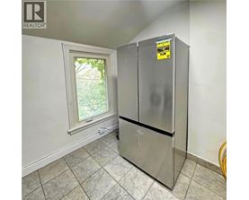 A small kitchen with a refrigerator and a window.