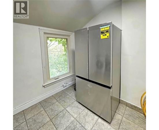 A small kitchen with a refrigerator and a window.