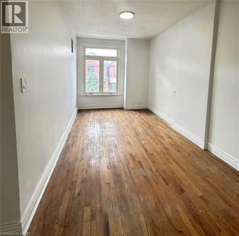 A room with wooden flooring and a white door.
