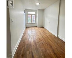 A room with wooden flooring and a white door.