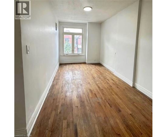 A room with wooden flooring and a white door.