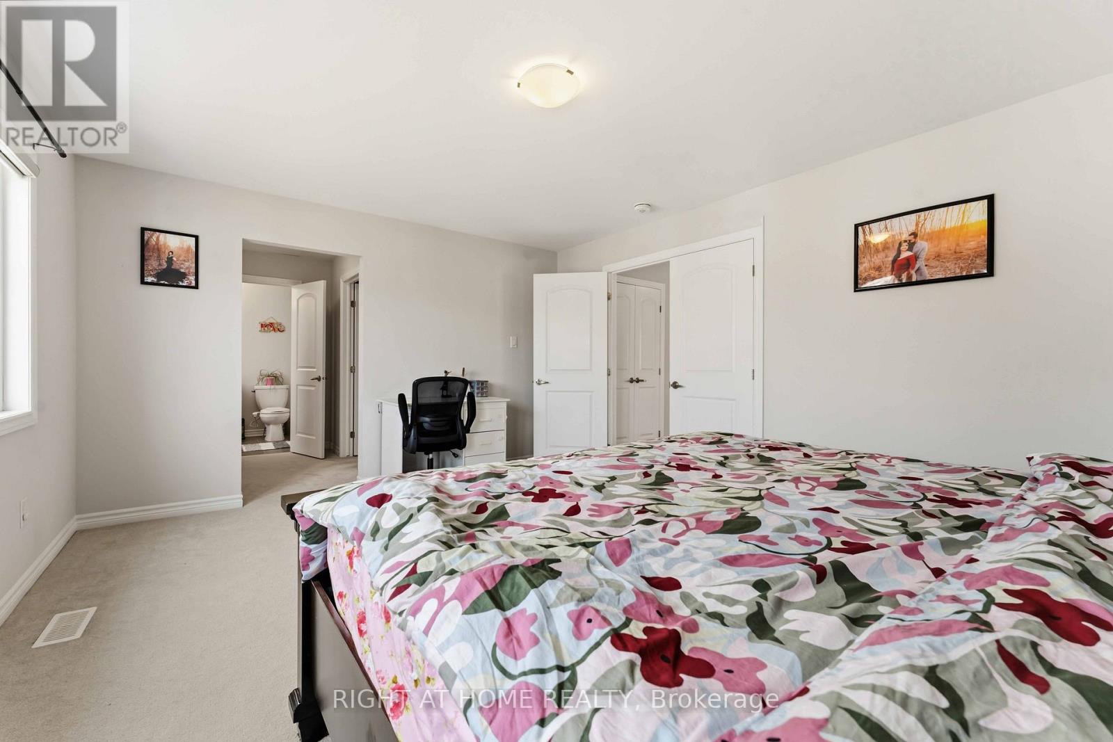A bedroom with a bed covered in a floral print bedspread.