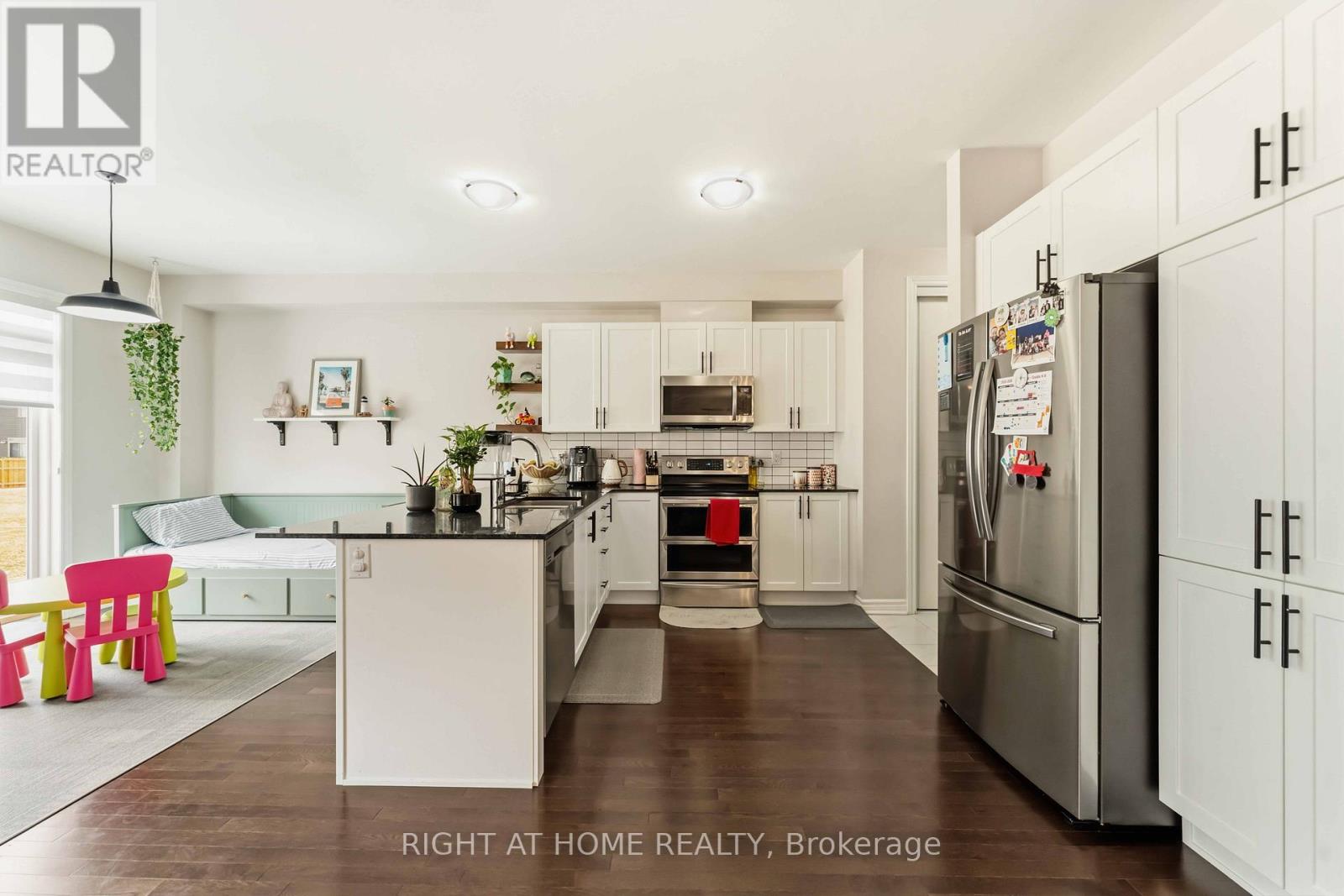 A kitchen with white cabinets and a refrigerator.