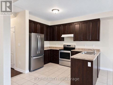 A kitchen with dark brown cabinets and stainless steel appliances.