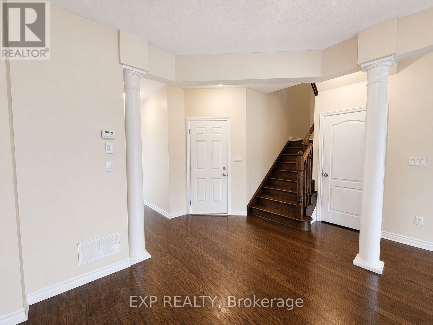 A spacious room with a staircase leading to the second floor.