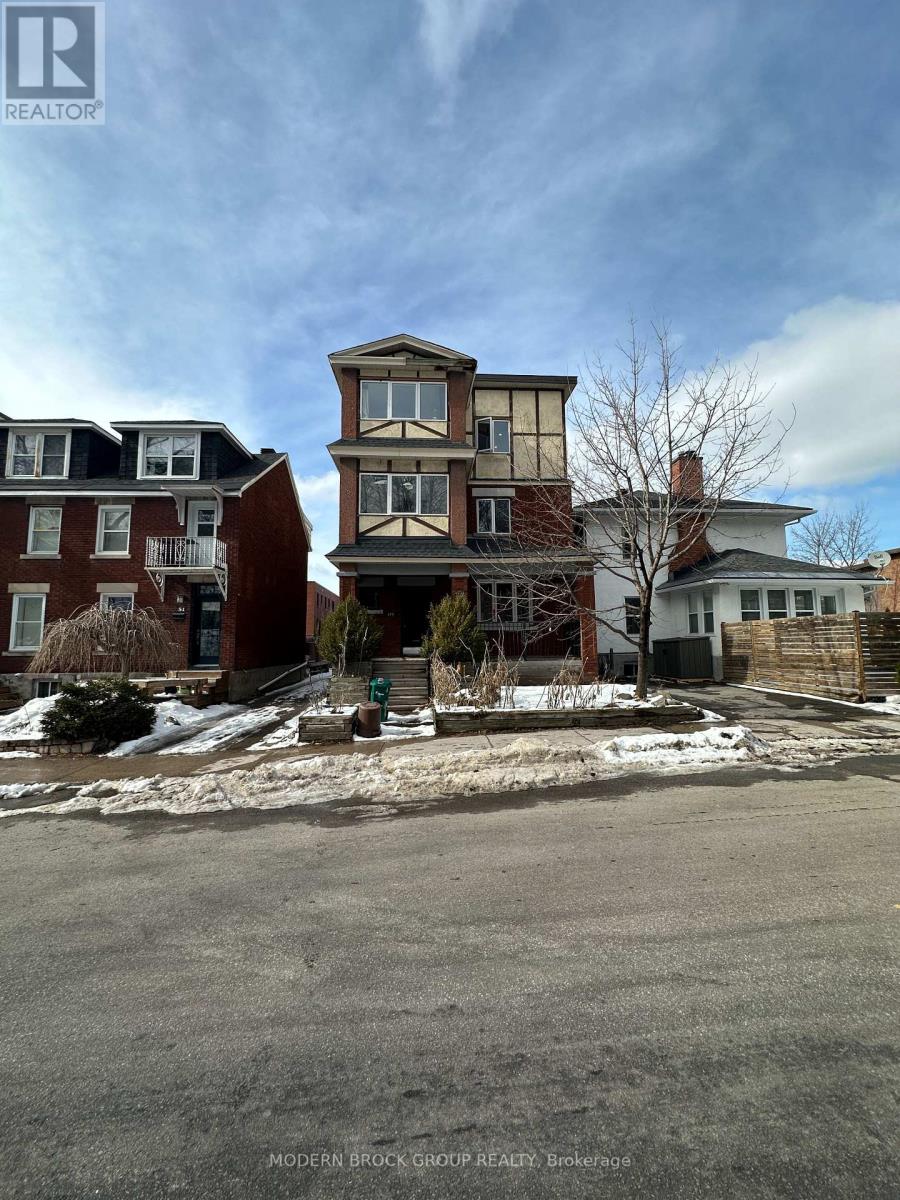 A street view of a residential area with houses and a sign for Modern Brock Grove Realty.