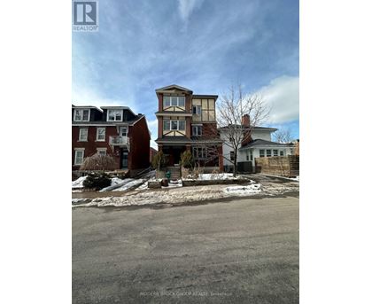 A street view of a residential area with houses and a sign for Modern Brock Grove Realty.